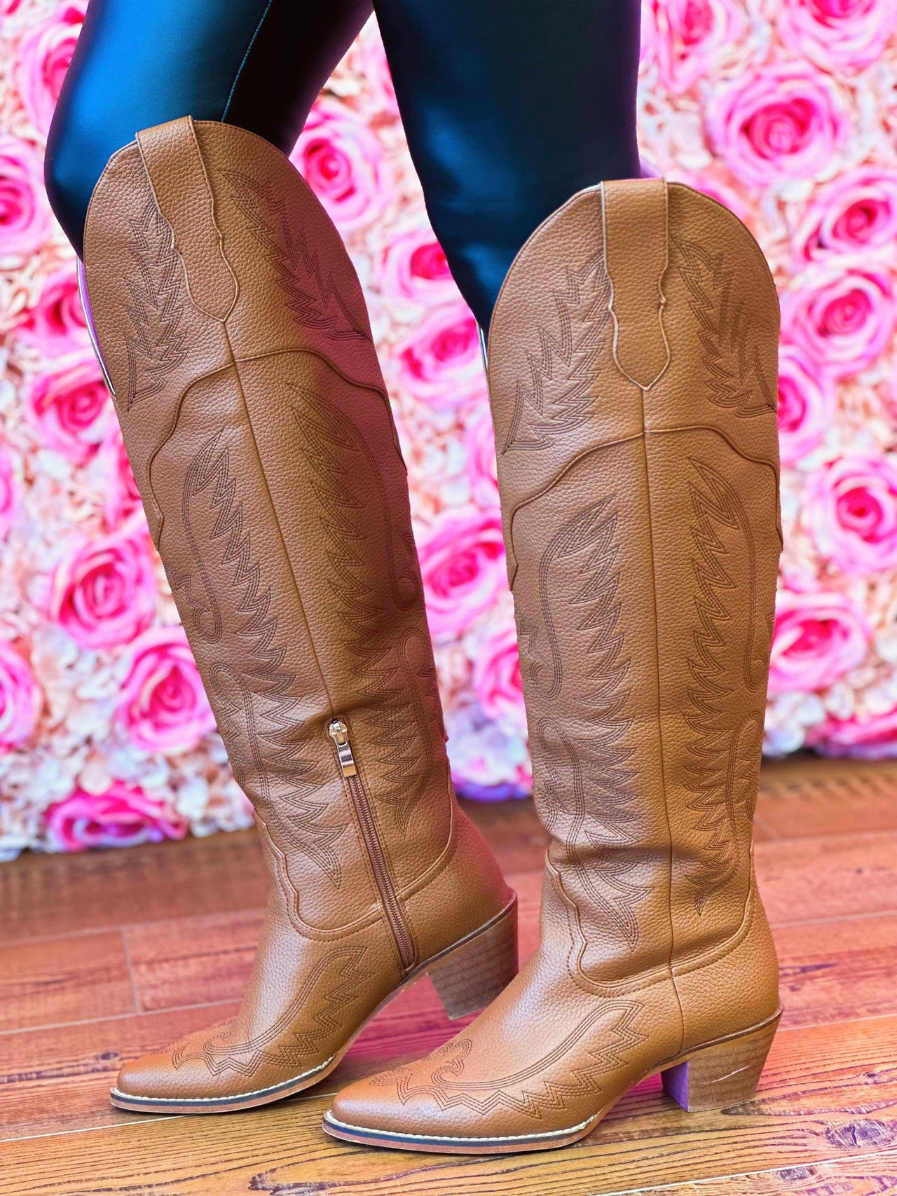 Brown leather knee high western boots.