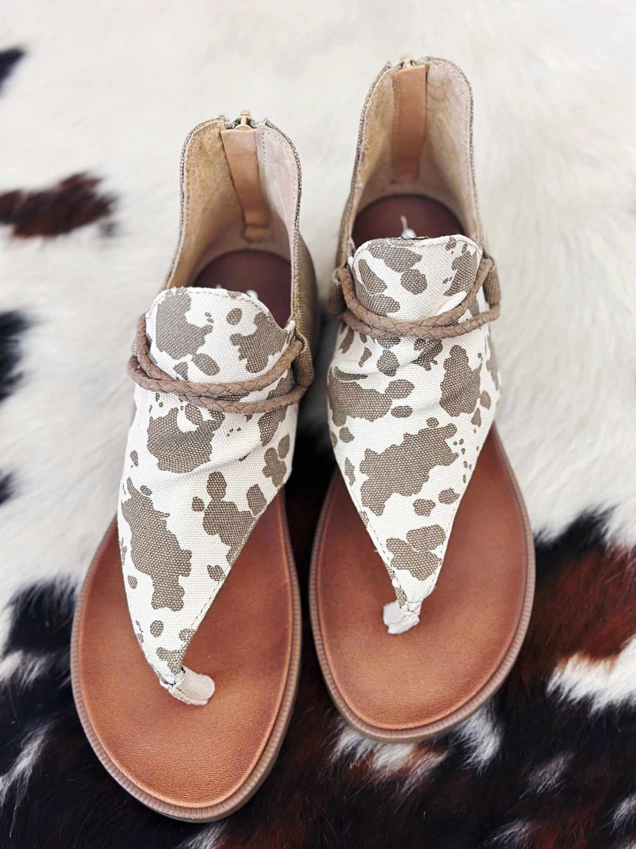 Taupe cow print thong sandal with zipper back.