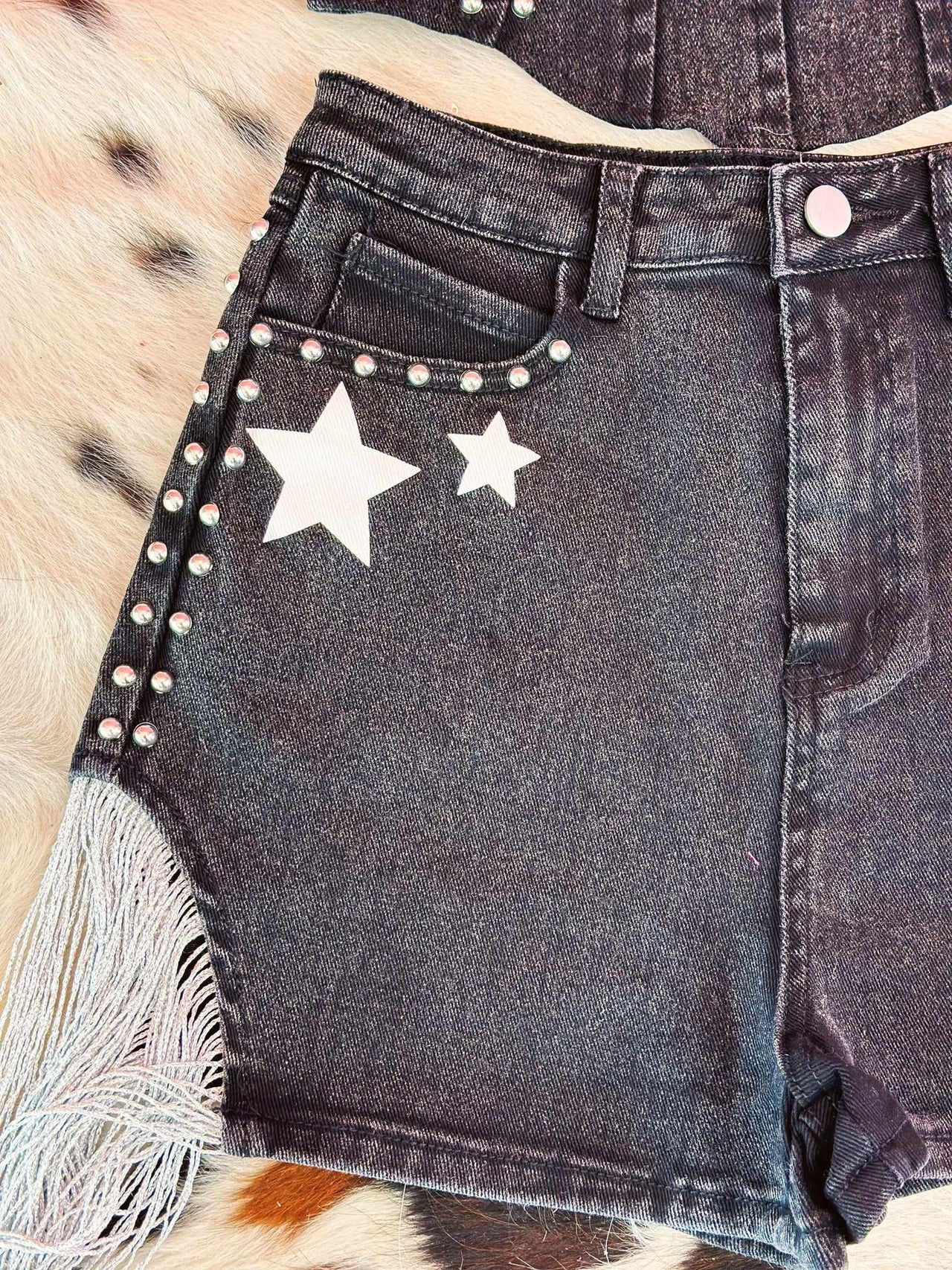 Black denim shorts with stars.