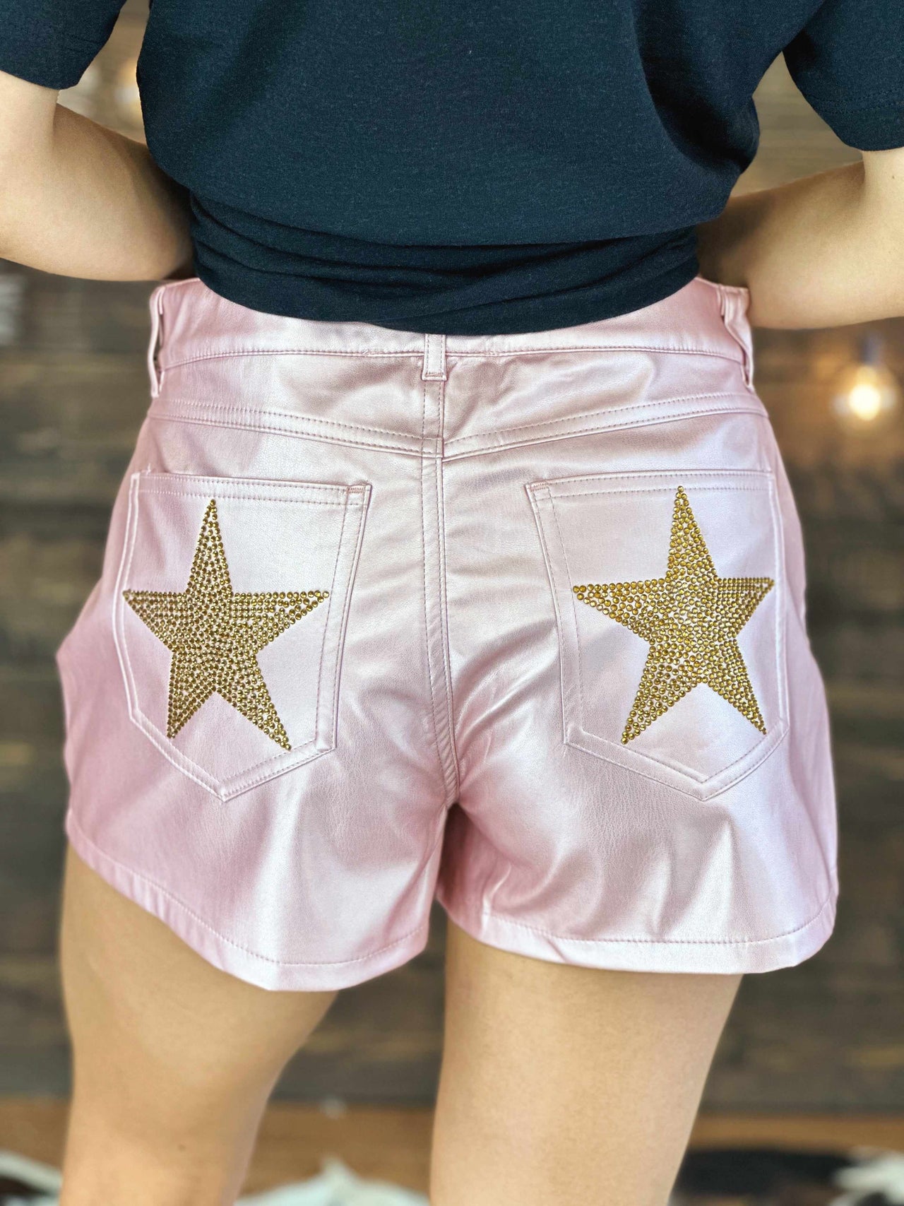 Pink faux leather shorts with stars.