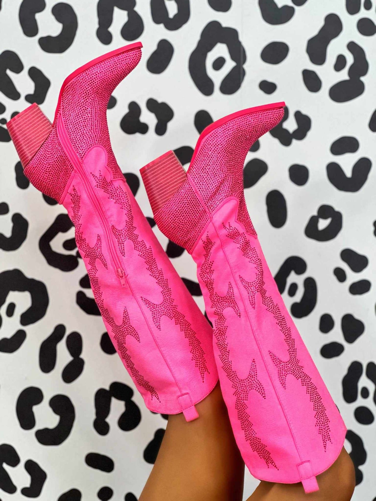 Pink knee high rhinestone western boots.
