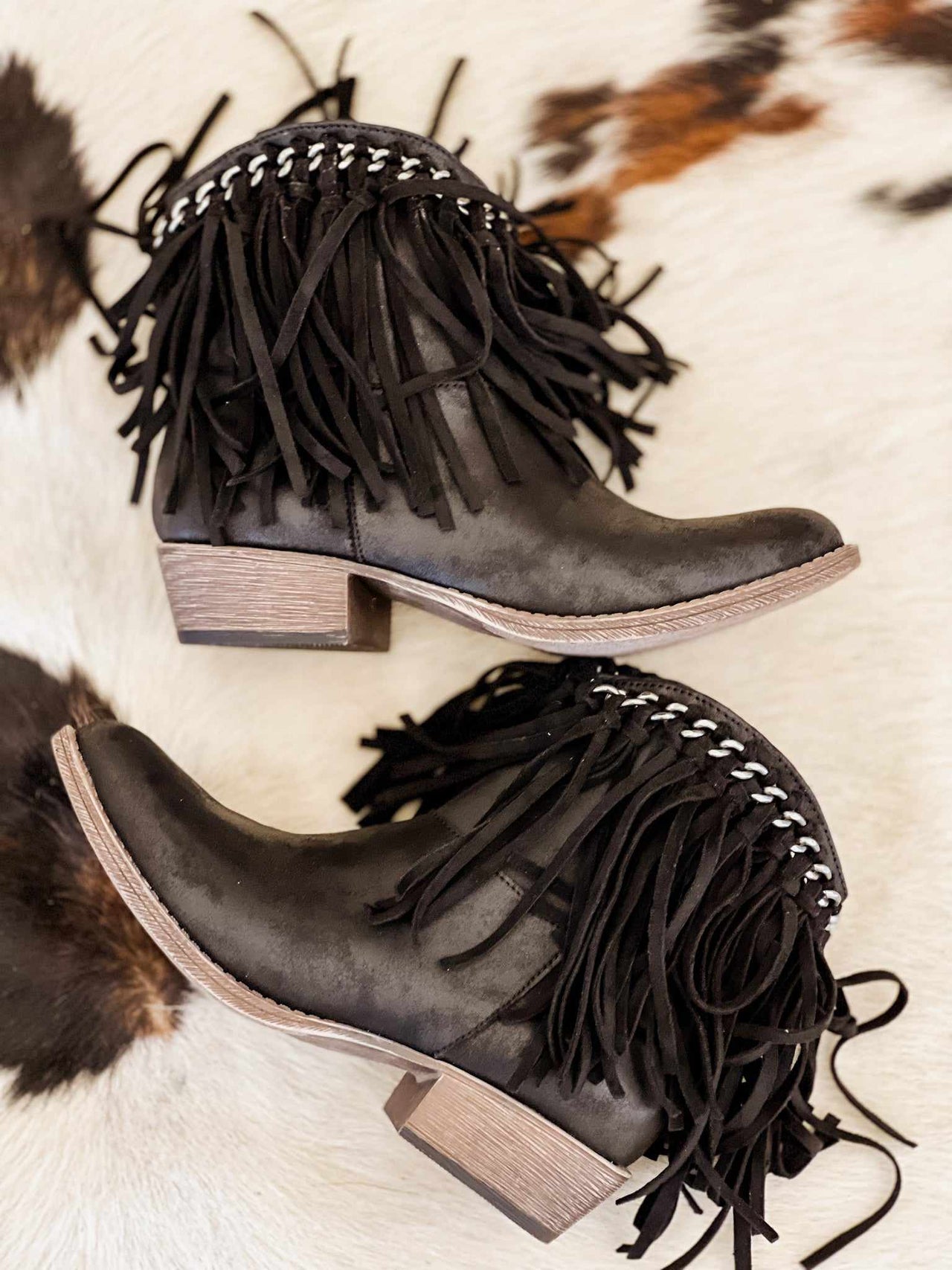 Black ankle boots with fringe.