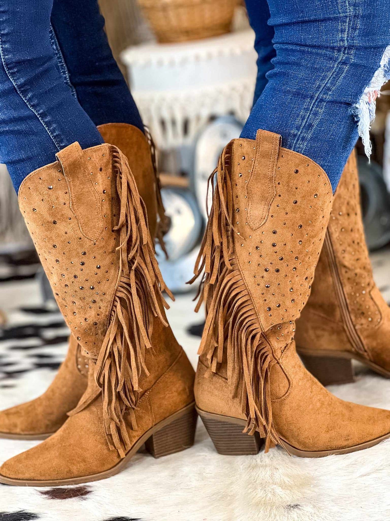 Brown fringe cowgirl boots in suede.