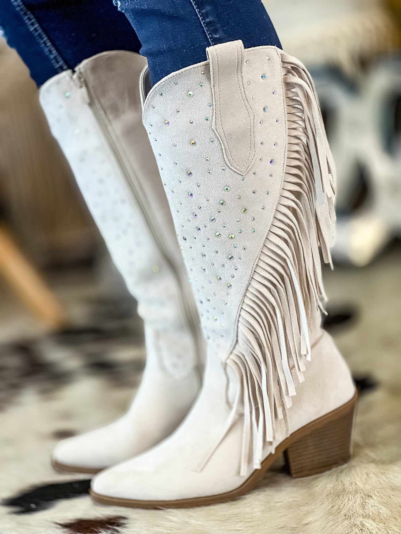 White suede fringe western boots with studs.