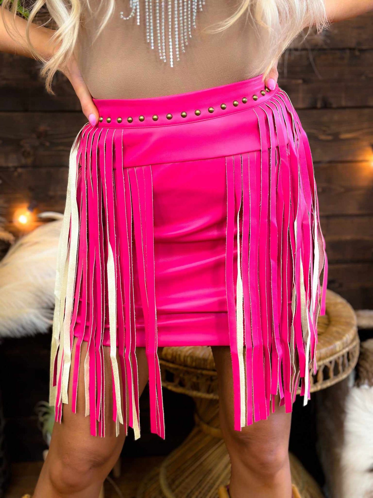 Pink faux leather mini skirt with fringe.
