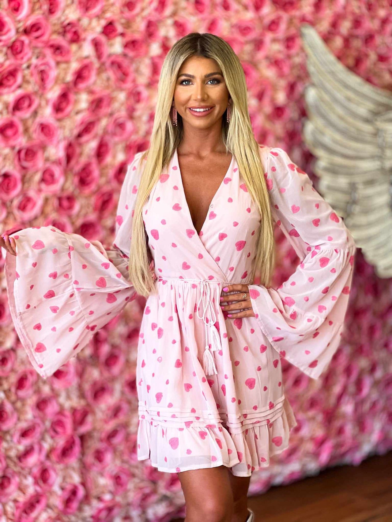 Pink heart print wrap dress with bell sleeves.