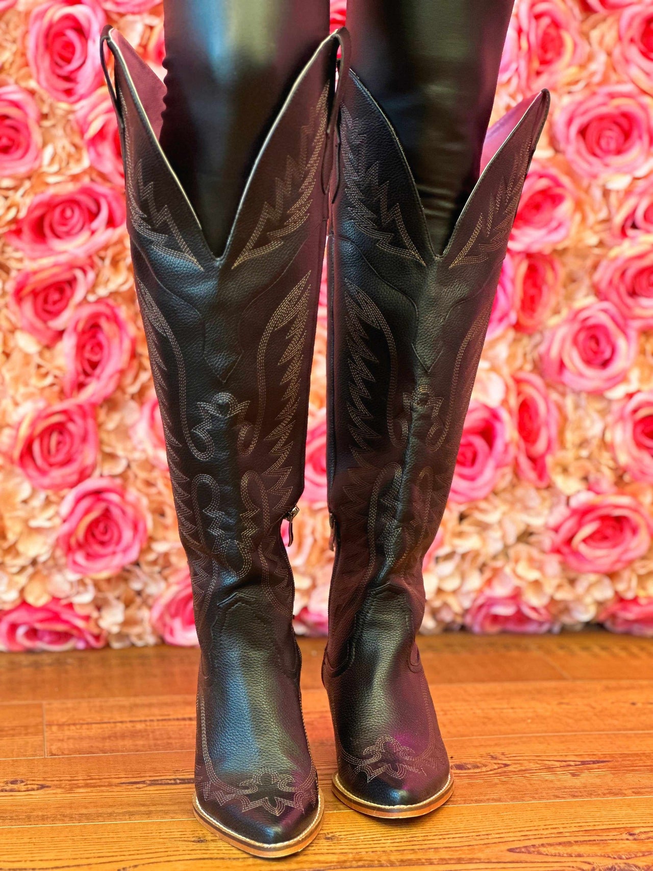 Black knee high cowgirl boots.